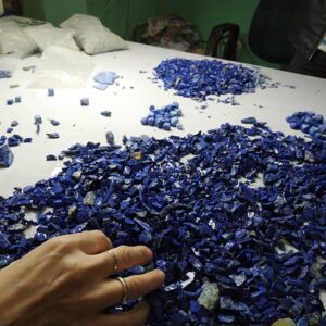 A photo of a hand selecting blue lapi stones.